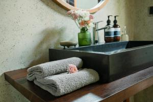 uma casa de banho com um lavatório e toalhas num balcão de madeira em The Surf Shack - Stylish New 1 BR Studio w/ plunge pool em Uluwatu