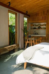 um quarto com uma cama e uma mesa com uma cozinha em The Surf Shack - Stylish New 1 BR Studio w/ plunge pool em Uluwatu