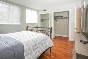 a bedroom with a bed and a dresser and a television at Cozy 3 Bedroom Min to National Mall Great Location and Free Parking in Arlington