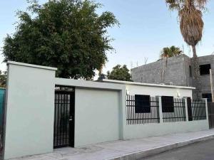 a white building with a gate and a fence at Depa Danzante in Loreto