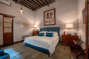 ein Schlafzimmer mit einem großen Bett mit blauen Kissen in der Unterkunft Antiguo Molino de San Jerónimo in Mexiko-Stadt