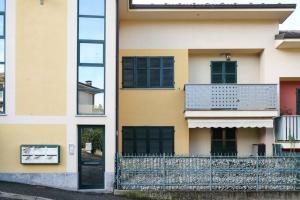 un edificio con finestre con persiane nere e una recinzione di Zephyr B&B apartment a Novi Ligure