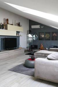 a living room with a couch and a television at Zephyr B&B apartment in Novi Ligure