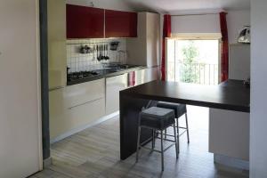 una cucina con bancone nero e sgabelli di Zephyr B&B apartment a Novi Ligure