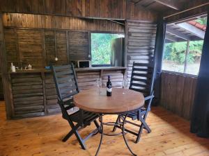 a table with two chairs and a bottle of wine at Cozy cabin with fireplace in San José