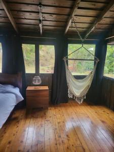 a bedroom with a hammock hanging from the ceiling at Cozy cabin with fireplace in San José