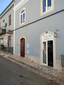 a white building with a door on a street at Penedo Grande suítes T2 in São Bartolomeu de Messines