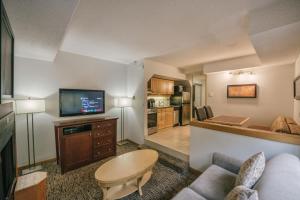 a living room with a couch and a tv at Executive Inn Whistler in Whistler