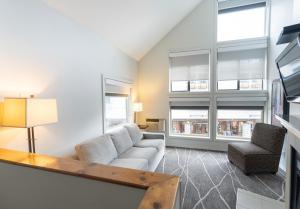 uma sala de estar com um sofá e duas janelas em Executive Inn Whistler em Whistler