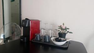 un tavolo con macchinetta del caffè, tazze e piante di Street Art Inn Florence a Firenze