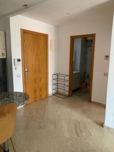an empty room with a wooden door and a bathroom at Appartement propre et calme in Casablanca