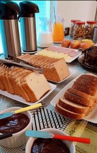 a table topped with lots of different types of bread at Hostel Kaizen in Curitiba