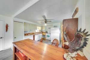 a kitchen with a wooden table and a refrigerator at Charming Cottage in Libby with Yard Pets Welcome! in Libby