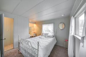 a bedroom with a white bed and a window at Charming Cottage in Libby with Yard Pets Welcome! in Libby
