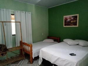 due letti in una stanza con pareti verdi di Pousada Da Mata a Pirenópolis