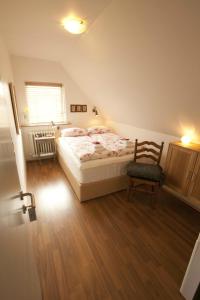 a bedroom with a bed and a chair and a window at Minna-Mosfell Guesthouse in Mosfellsbær