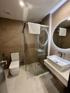 La salle de bains est pourvue d'une douche, de toilettes et d'un lavabo. dans l'établissement Hôtel AL AFIFA, à Dakar