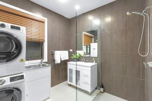 a bathroom with a washing machine and a washer at Husky Days in Huskisson +9 photos
