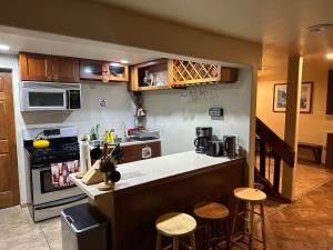 a kitchen with a counter and some stools in it at Forget me not Home in Anchorage