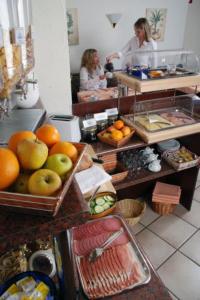 Dos mujeres en una cocina con fruta en un mostrador en Hotel am Wilhelmsplatz, en Stuttgart
