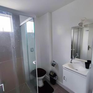 a bathroom with a shower and a toilet and a sink at Apartamento Pertinho da Praia, faça tudo a pé! in Balneário Camboriú
