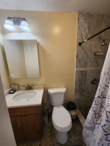 een badkamer met een toilet, een wastafel en een spiegel bij Impressive 2Bedroom Apt Close to NYC in Union City