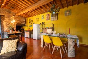 a kitchen with a table and yellow walls at Quinta Morazes Casas de Campo in Ribeira Grande