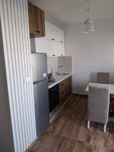 a kitchen with a refrigerator and a table with a chair at Obilex in Podgorica