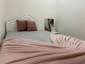 uma cama com um cobertor rosa em cima em DayDream Apartament em Viana do Castelo