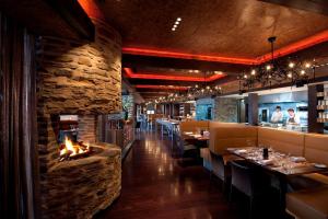 a restaurant with a fireplace in the dining room at DoubleTree by Hilton Queenstown in Queenstown