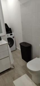 a bathroom with a toilet and a washing machine at DayDream Apartament in Viana do Castelo
