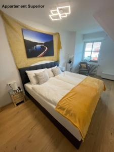 a bedroom with a bed with a yellow blanket on it at Villa Sunside Schluchsee - Appartements Modern Style & Superior in Schluchsee +11 photos