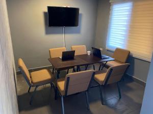 a conference room with a table and chairs with laptops at Smart Inn in San Pedro Sula