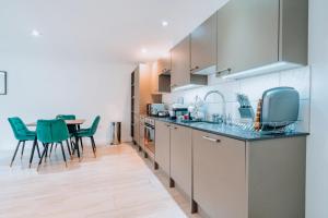 a kitchen with a table and green chairs at Two Bedroom Urban Retreat in the Heart of Exeter in Exeter