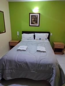 a bedroom with a large bed with two towels on it at Hotel Misky Samay in Ayacucho