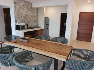 uma cozinha com uma mesa de madeira e cadeiras em Noah Beach Hotel & Suites em Mahahual