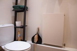 a bathroom with a toilet and a towel rack at Cozy bedroom in Clapton home in London