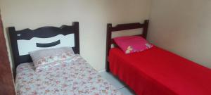 Dos camas una al lado de la otra en una habitación. en Chalé Sitio Miranda Sra Solange, en Aratuba