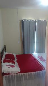 una cama con sábanas rojas y blancas y una cortina en Chalé Sitio Miranda Sra Solange, en Aratuba 17 fotos más