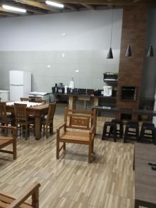 Habitación con mesas y sillas de madera y cocina. en Aconchego da canastra en Delfinópolis