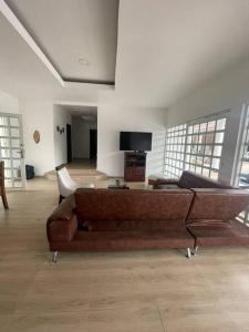a living room with a brown couch and a tv at Finca y Piscina de Ensueño in El Cerrito