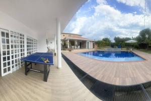 a patio with a ping pong table and a swimming pool at Finca y Piscina de Ensueño in El Cerrito