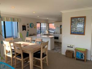 a dining room and kitchen with a table and chairs at Grace Getaway - Beach, Cafes & The Mount at your doorstep in Mount Maunganui