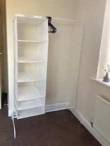 a white book shelf in the corner of a room at LovelyHome 4 family& Contractors in Killingbeck