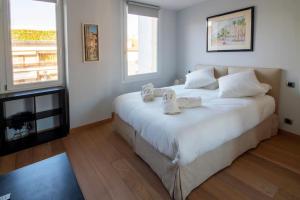 1 dormitorio con 1 cama blanca grande y toallas. en T3 vue mer LE MACE PLAGE, en Cannes