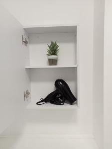 un téléphone noir assis sur une étagère dans une pièce dans l'établissement LovelyHome 4 family& Contractors, à Killingbeck