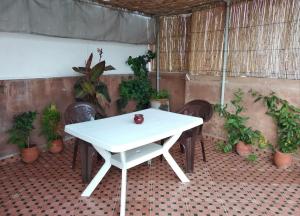 a white table and chairs in a room with plants at KAYEZER in Rabat