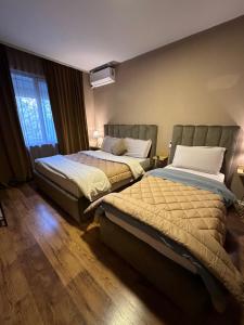 - une chambre avec 2 lits et une fenêtre dans l'établissement BejartApartment2, à Tirana
