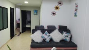 a black couch with white fluffy pillows on it at Casa Shalom R.G. in Paipa
