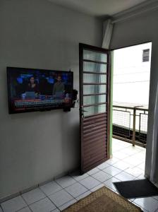 a flat screen tv on a wall next to a door at Apto Prático n.07 in Cascavel